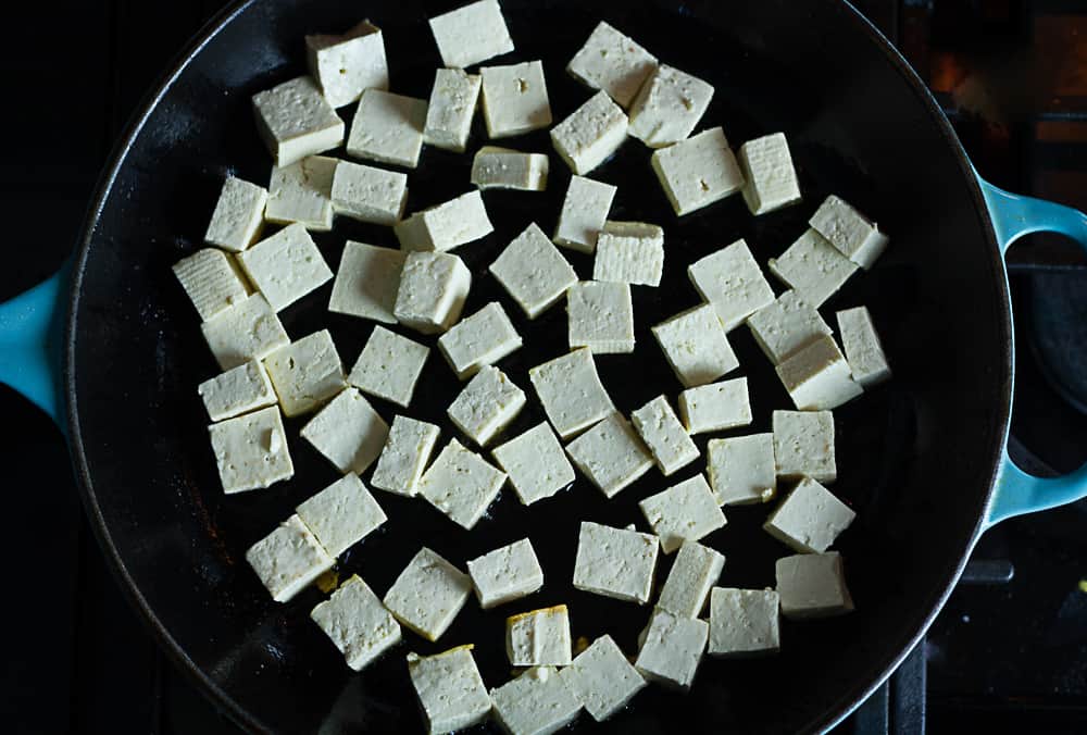 Crispy tofu is being pan seared.