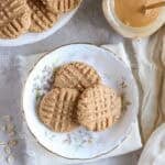 Peanut butter protein cookies on a white plate with gold trim