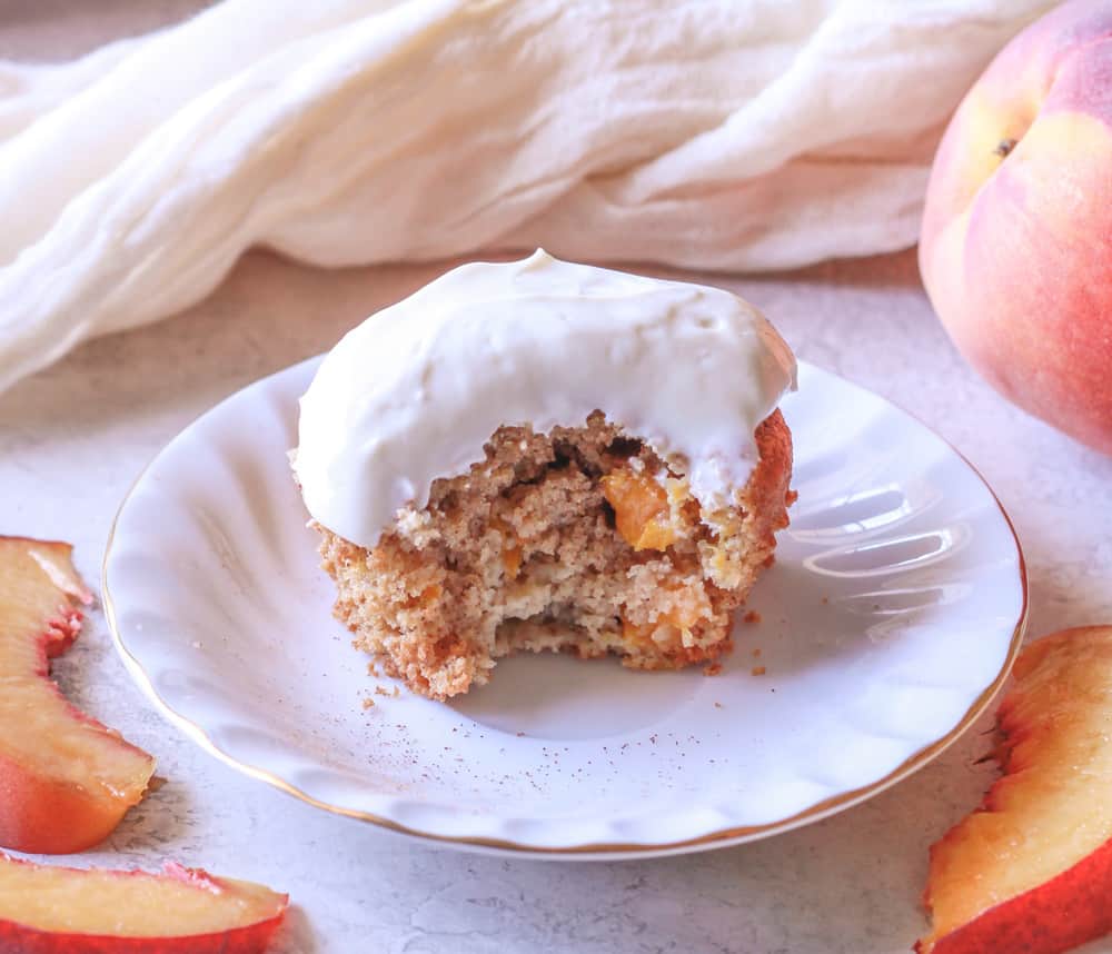 A healthy peach muffin with a bite taken out.