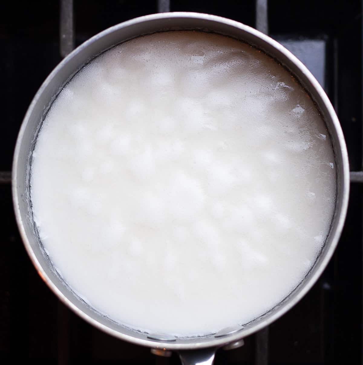 rice and coconut milk simmering in a pan