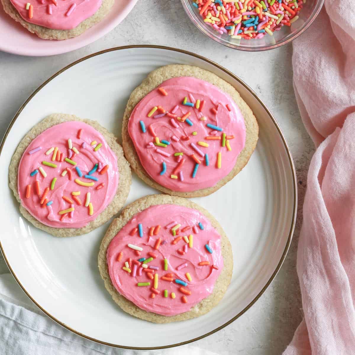 healthy oat flour sugar cookies on a white plate with sprinkles