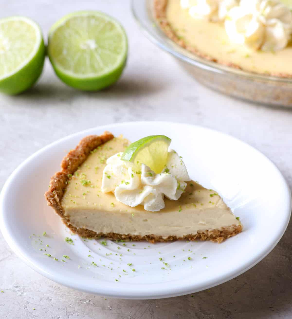 a slice of key lime pie with whipped topping and a lime slice