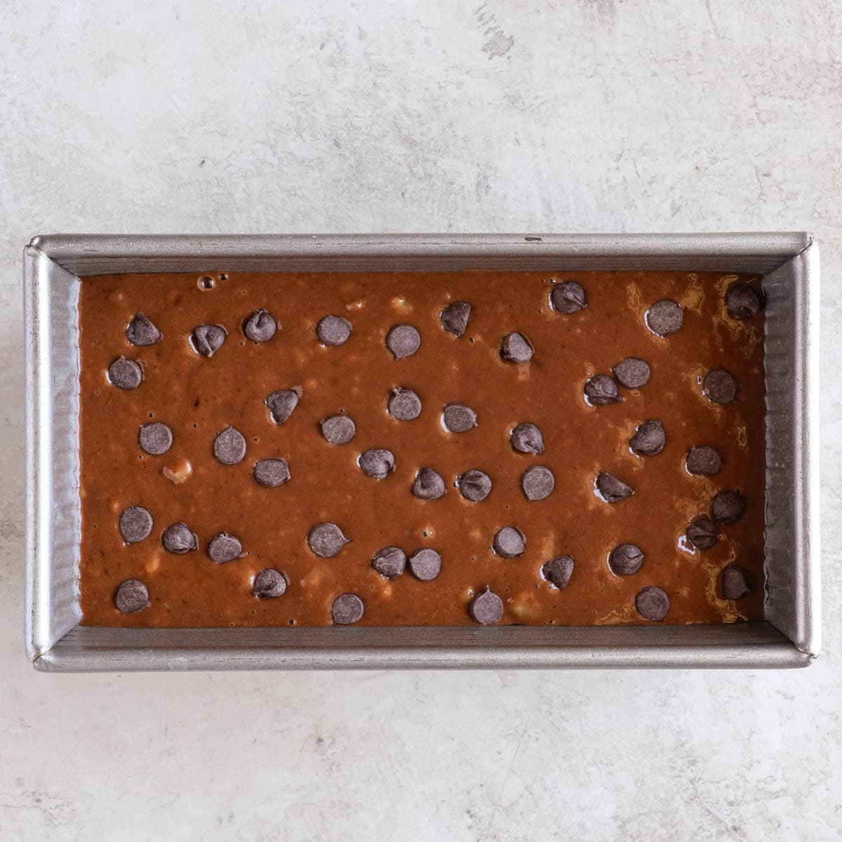 chocolate banana bread batter in a loaf tin before being baked