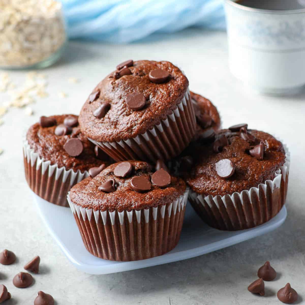 Moist chocolate banana protein muffins made with oat flour on a blue plate