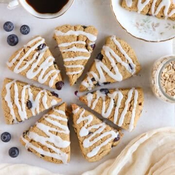 blueberry oat flour scones drizzled with vanilla glaze