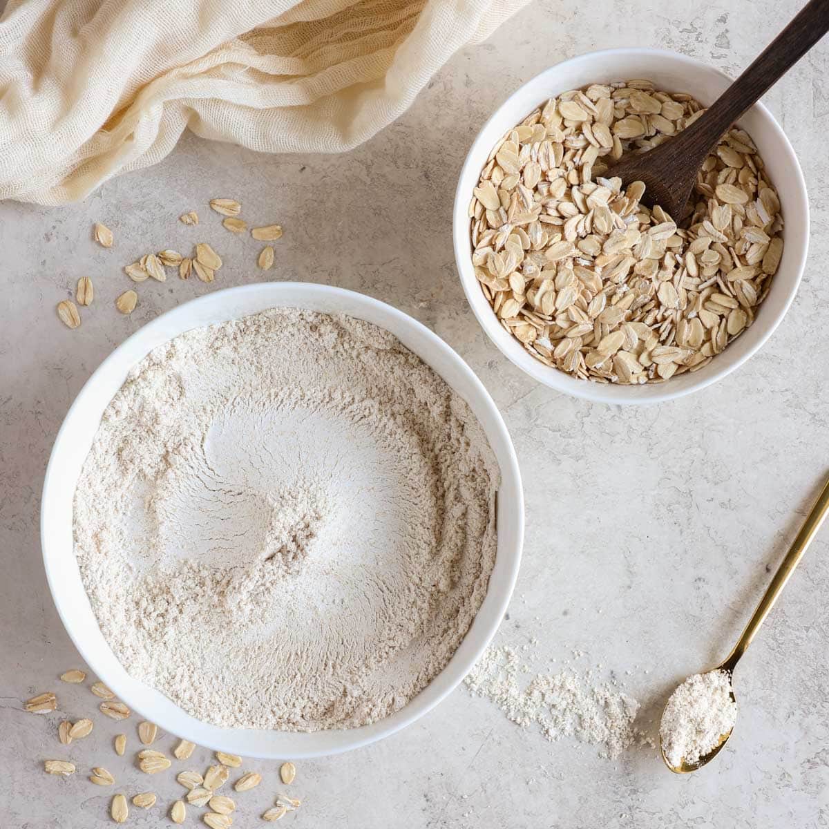 Homemade oat flour in a bowl with whole oats beside it
