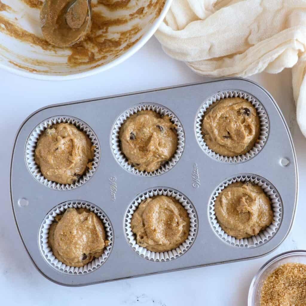 oat flour muffin batter scooped into a muffin tin ready to bake