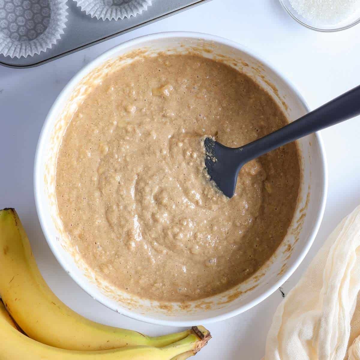 Oat flour banana muffin batter in a mixing bowl before baking