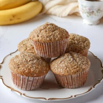 Tall, fluffy oat flour banana muffins with a crunchy sugar topping