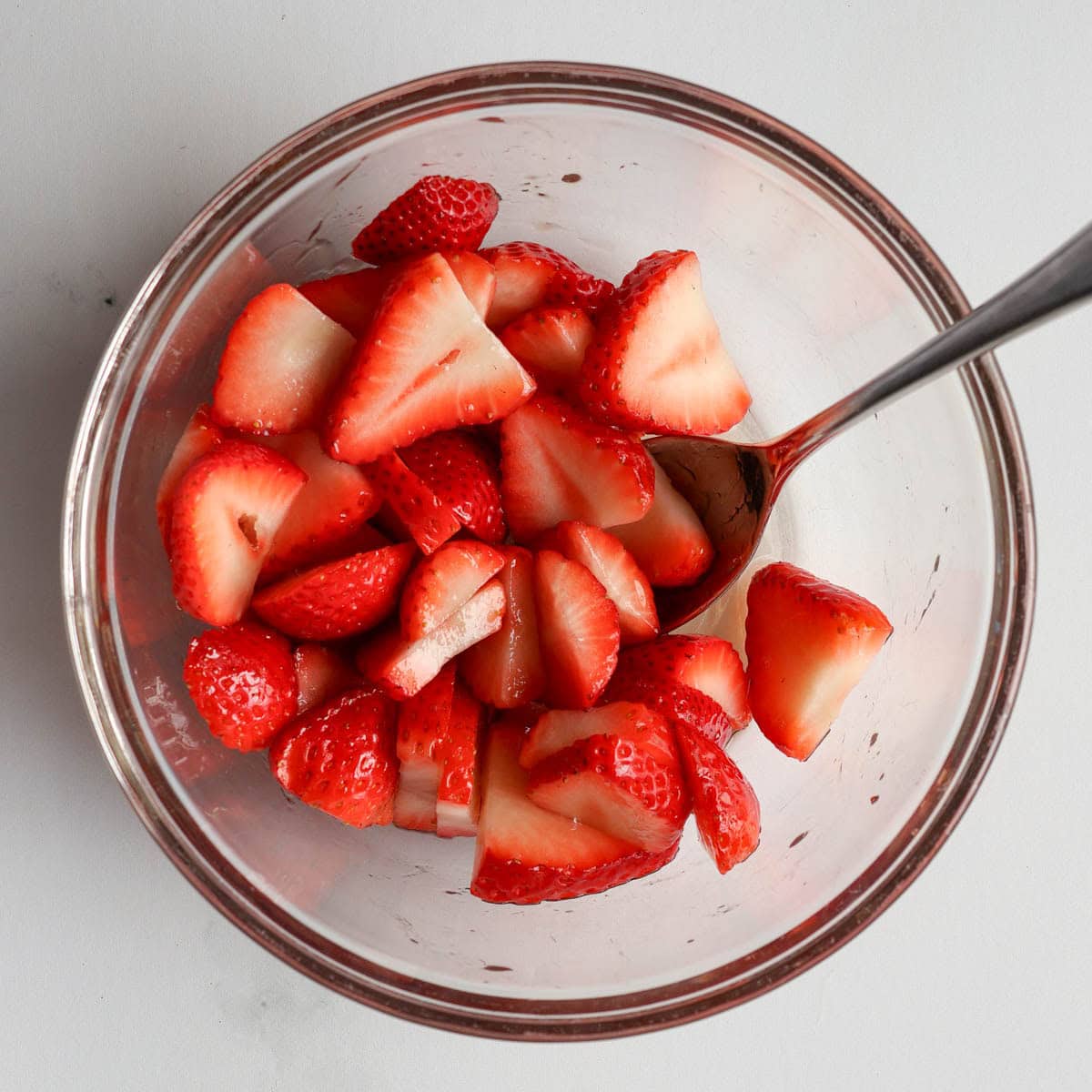 Fresh sliced strawberries tossed with maple syrup for strawberry shortcake topping