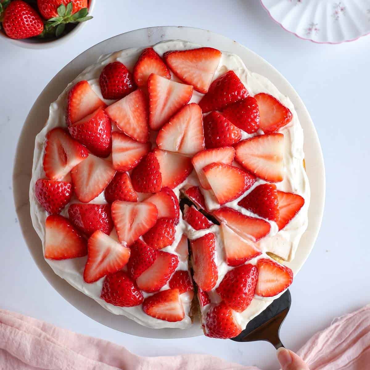 Top-down view of healthy strawberry shortcake cake topped with maple yogurt cream and fresh strawberries