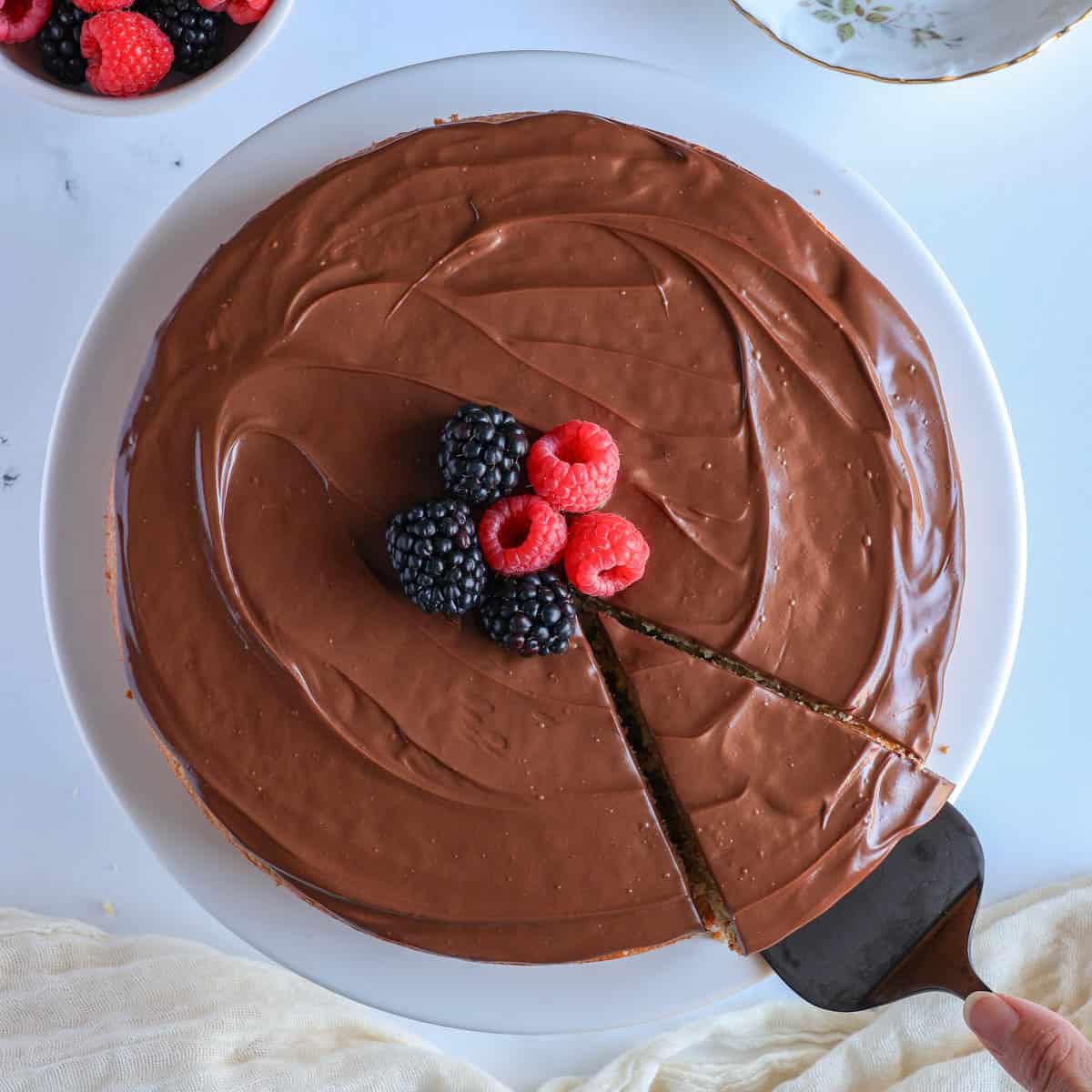 protein cake with chocolate fudge frosting topped with berries