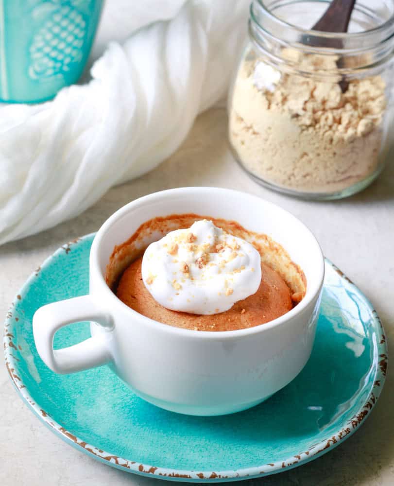 powdered peanut butter mug cake topped with whipped cream